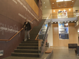 Person out of focus walking down the stairs in the Public Policy Building atrium.