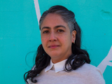 Picture of Dr. María Célleri with a blue wall background.
